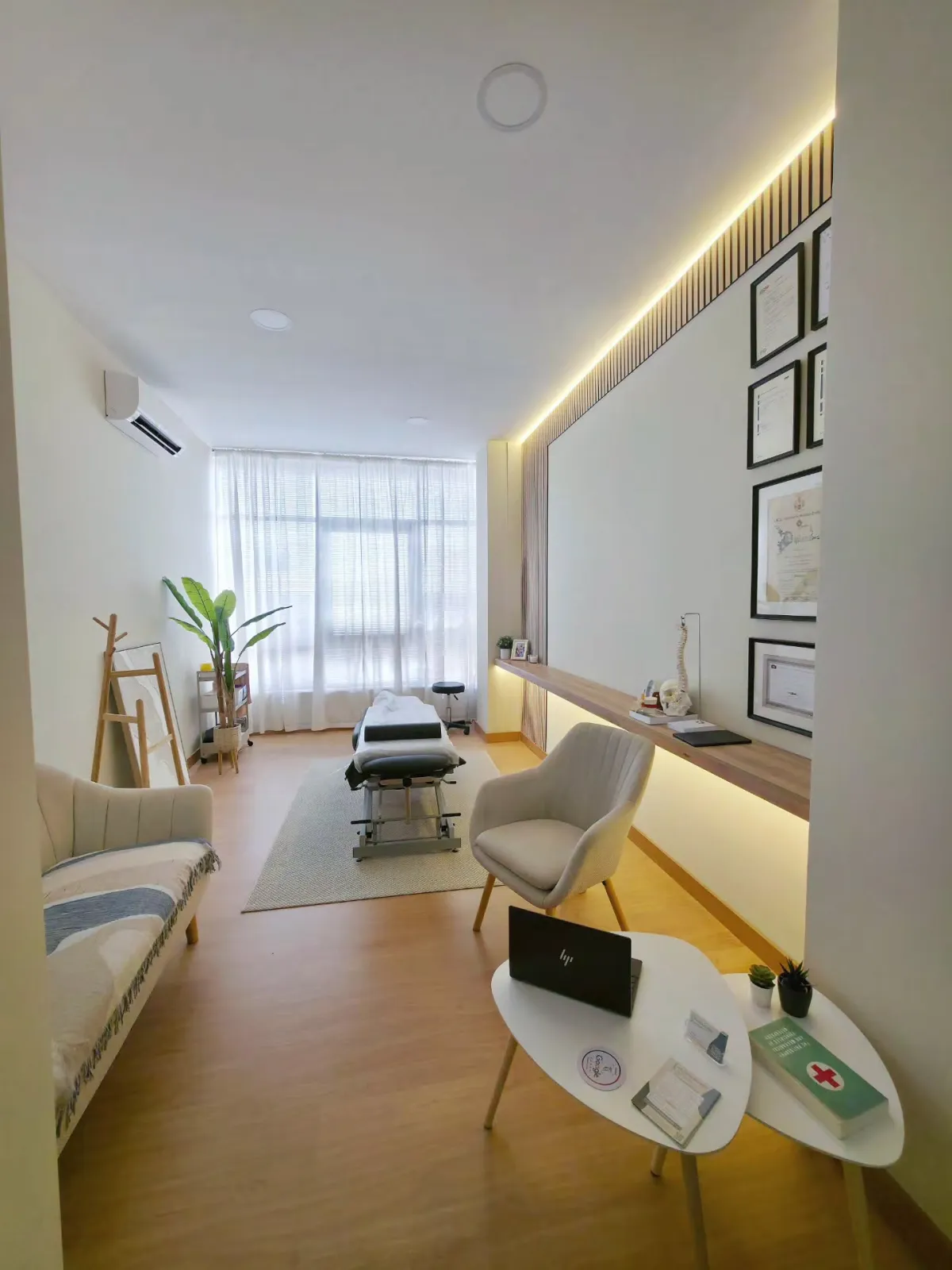 Consultório de osteopatia com marquesa, poltrona e luz natural