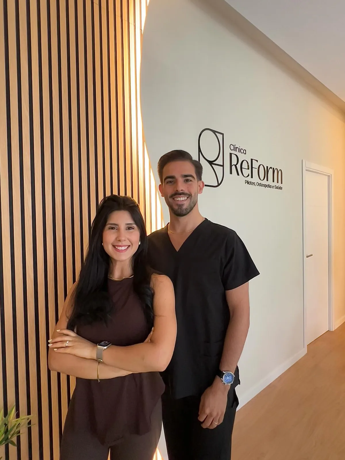 Equipa da Clínica ReForm junto ao logótipo da clínica, na entrada